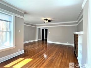 Chicago apartment for rent - A spacious room with wood flooring and a ceiling fan.