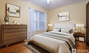 Chicago apartment for rent - A bedroom with a large bed, a dresser, and a window with curtains.