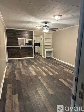 Enid house for rent - A room with wooden flooring and a ceiling fan.