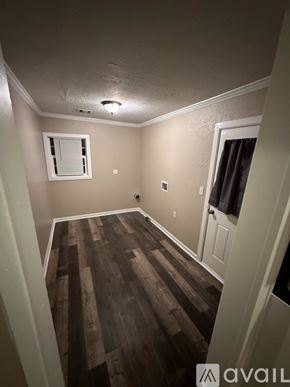 Enid house for rent - A room with wooden flooring and a window with closed curtains.