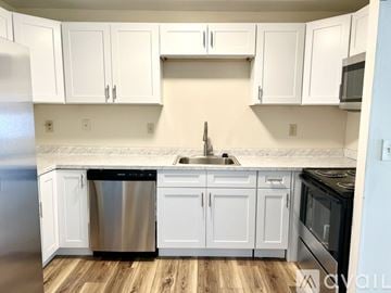 Canton condo for rent - A kitchen with white cabinets and a wooden floor.
