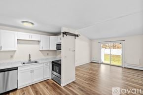 Canton condo for rent - A kitchen with white cabinets and a black stove top oven.