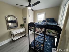 Ventnor City house for rent - A bedroom with a bunk bed and a desk with a mirror on the wall.