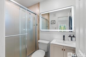 Fort Lauderdale apartment for rent - A modern bathroom with a toilet, sink, and mirror.