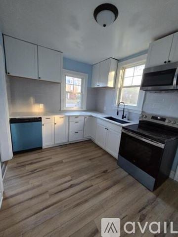 Hopewell house for rent - A kitchen with white cabinets and a wooden floor.