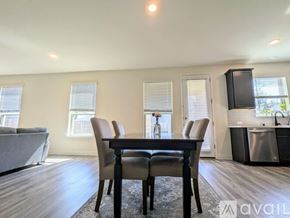 Prosper house for rent - A dining room with a table and chairs in the foreground and a kitchen area in the background.