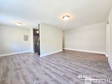 Chicago condo for rent - A white oven in a kitchen with a wooden door in the background.