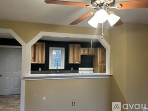 Louisa apartment for rent - A kitchen with a fan and a window with curtains.