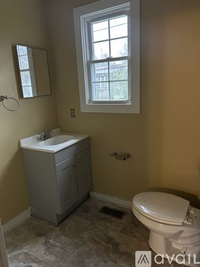 Louisa apartment for rent - A bathroom with a toilet, sink, and window.