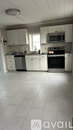 Louisa apartment for rent - A kitchen with white cabinets and appliances.