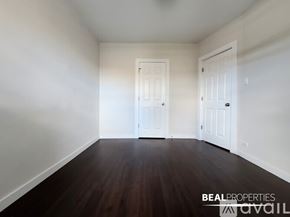 Chicago condo for rent - A room with wooden floors and white walls, with two doors and a window.