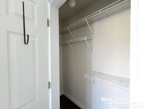 Chicago condo for rent - A white door is open to a small, empty closet with a metal rack.