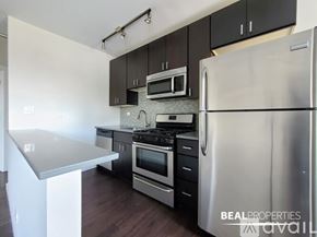 Chicago condo for rent - A kitchen with a refrigerator, stove, and microwave.