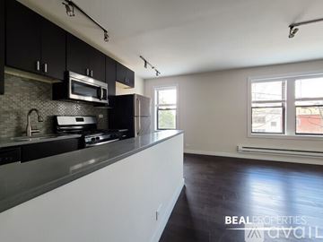 Chicago condo for rent - A kitchen with black cabinets and a white countertop.