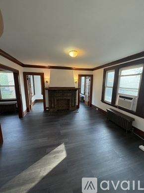 Irvington apartment for rent - A spacious room with wooden floors and a fireplace.