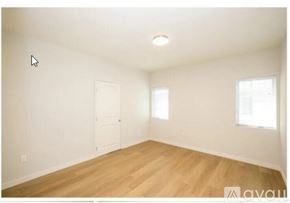 Burbank apartment for rent - A room with wooden floors and white walls, with a door and a window.