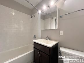 Chicago condo for rent - A room with a brick wall and a wood floor.