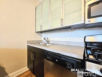 Chicago condo for rent - A kitchen with a black dishwasher and a white countertop.
