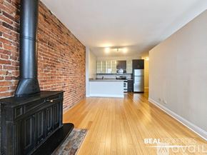 Chicago condo for rent - A living room with a fireplace and wooden floors.