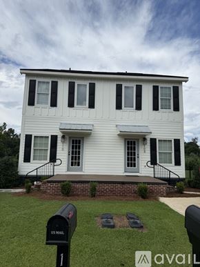 Thomasville townhouse for rent - A white house with black shutters and a mailbox in front.