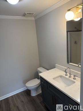 Thomasville townhouse for rent - A bathroom with a toilet, sink, and mirror.