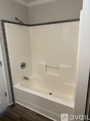 Thomasville townhouse for rent - A white bathtub with a grey tile border is in a bathroom.