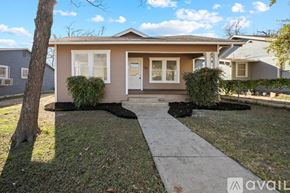 San Antonio house for rent - A small house with a white door and windows is surrounded by a lawn and a sidewalk.