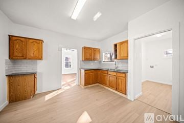 San Antonio house for rent - A kitchen with wooden cabinets and a grey backsplash is available for rent.