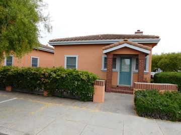 Half Moon Bay apartment for rent - A small house with a green door and a grey window.