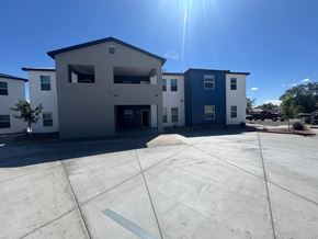 Rio Rancho apartment for rent - A sunny day at a parking lot with a building in the background.