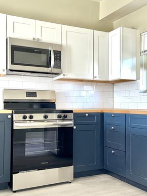 Rio Rancho apartment for rent - A kitchen with a black oven and white cabinets.