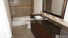 Burleson house for rent - A bathroom with a toilet, sink, and mirror.