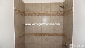 Burleson house for rent - A shower area with tiles and a shower head.