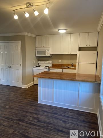 Spartanburg apartment for rent - A kitchen with white cabinets and a wooden countertop.