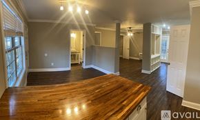 Spartanburg apartment for rent - A spacious room with a wooden floor and a large window on the left side.