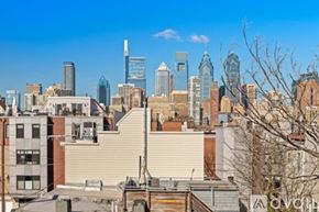Philadelphia house for rent - A cityscape with buildings of various heights and architectural styles under a clear sky.