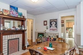 Madison apartment for rent - A living room with a fireplace and a dining table.