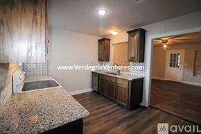 Fort Worth house for rent - A kitchen with a granite countertop and wooden cabinets.