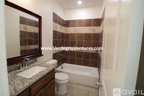 Fort Worth house for rent - A bathroom with a sink, toilet, and bathtub.