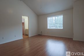 Shreveport townhouse for rent - A room with wooden floors and a window with a view of trees.
