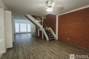 Shreveport townhouse for rent - A spacious room with a staircase and brick wall.
