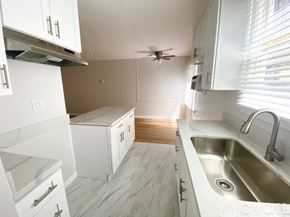 Los Angeles apartment for rent - A spacious room with wooden flooring and a large window.