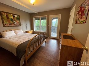 Breckenridge house for rent - A bedroom with a large bed and a wooden dresser.