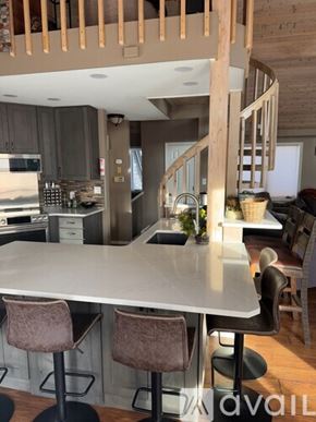 Breckenridge house for rent - A kitchen with a table and chairs in the foreground and a staircase in the background.