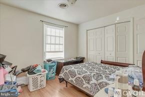 Hagerstown house for rent - A bedroom with a bed, a window with blinds, and a fan on the ceiling.