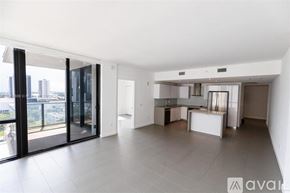 Miami condo for rent - A spacious, well-lit living area with a kitchen and a view of the city.