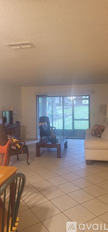 Ocala condo for rent - A living room with a white couch and a television.