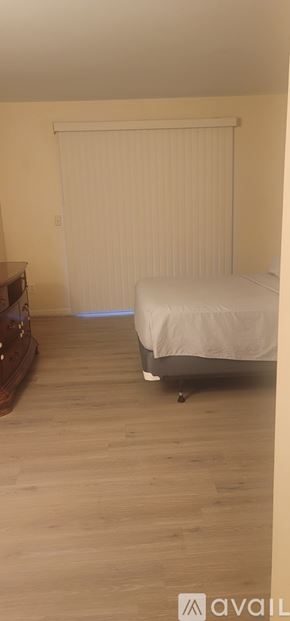Ocala condo for rent - A bedroom with a bed and a wooden dresser.
