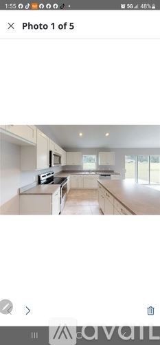 Ocala condo for rent - A modern kitchen with white cabinets and a central island.