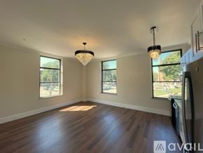 Elmira apartment for rent - A room with wooden floors and a chandelier hanging from the ceiling.